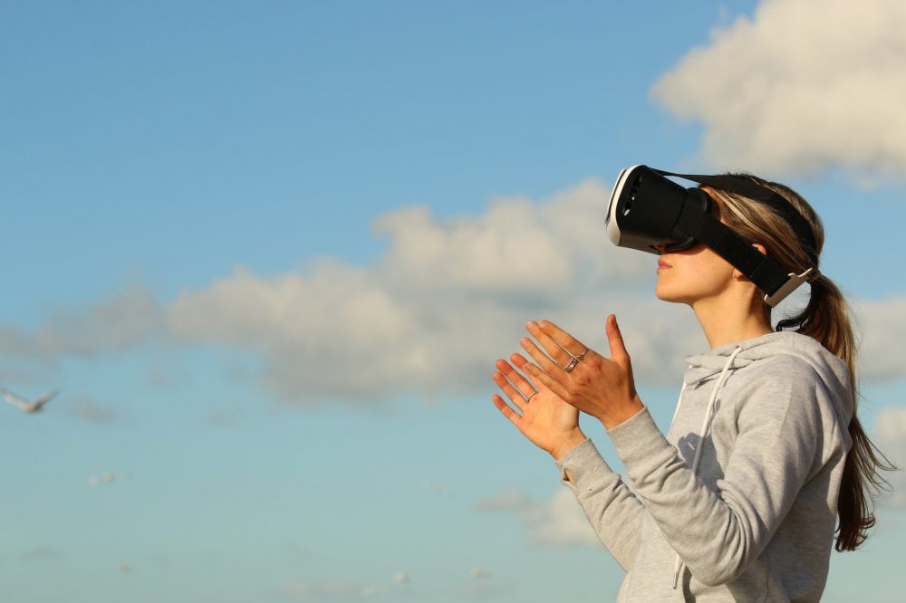 Hybrid Work Models - Techonoooy - woman using vr goggles outdoors